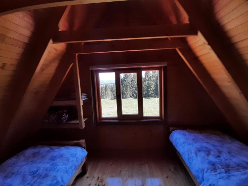 a attic room with two beds and a window at Braća Kosorić in Han Pijesak