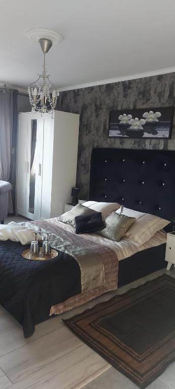 duże łóżko w sypialni z żyrandolem w obiekcie Pokoje u Camili w Rewie