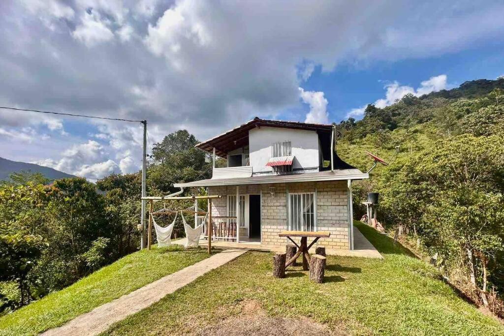 mały biały dom na wzgórzu z drzewami w obiekcie Cabaña Central y Acogedora con Wifi w mieście San Rafael