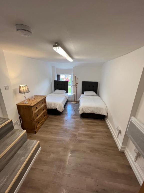 Habitación con 2 camas, vestidor y escaleras. en See the Sea Hideaway, en Mumbles
