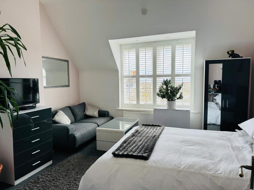 a bedroom with a bed and a couch at Penthouse Suite, Central St Leonards, Sea View in St. Leonards
