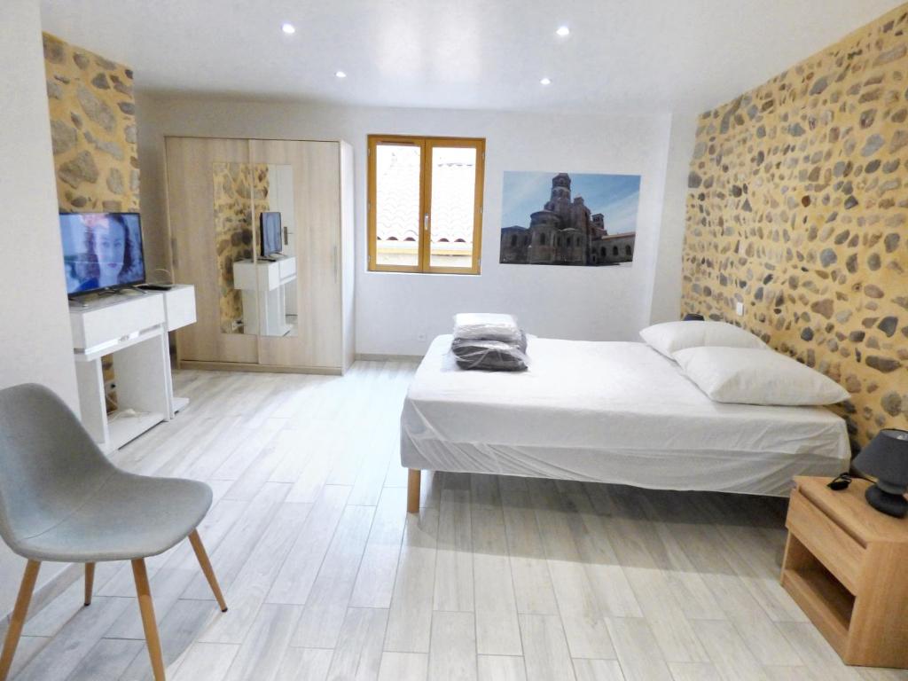 ブリウドにあるMaison de 3 chambres avec vue sur la ville et wifi a Brioudeのベッドルーム(ベッド1台、椅子、テレビ付)