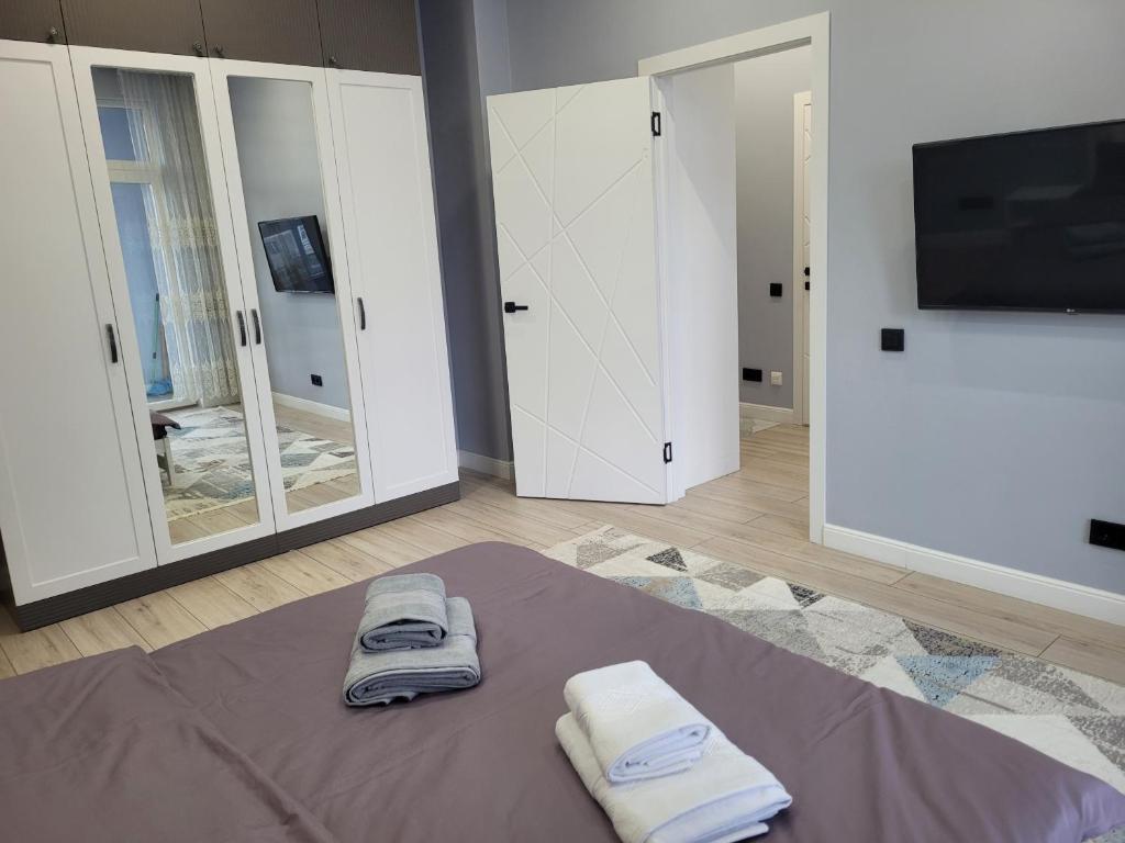 a room with two towels and a tv and mirrors at ЖК Apple City 1 СПАЛЬНЯ in Prigorodnyy