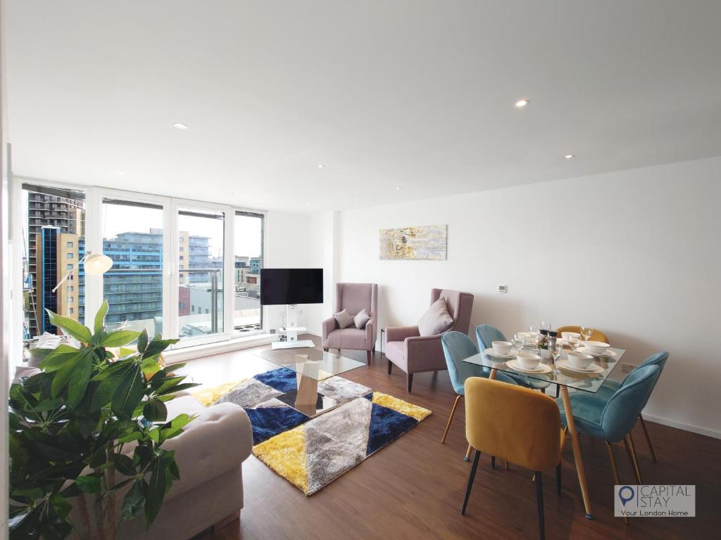 a living room with a table and chairs and a dining room at Deluxe Two Bed Apartment by London ExCeL & O2 in London