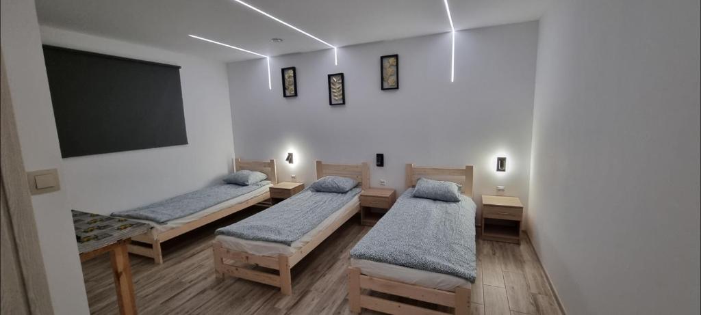 um quarto com 3 camas e uma televisão de ecrã plano em KOKON Noclegi Żuromin em Żuromin