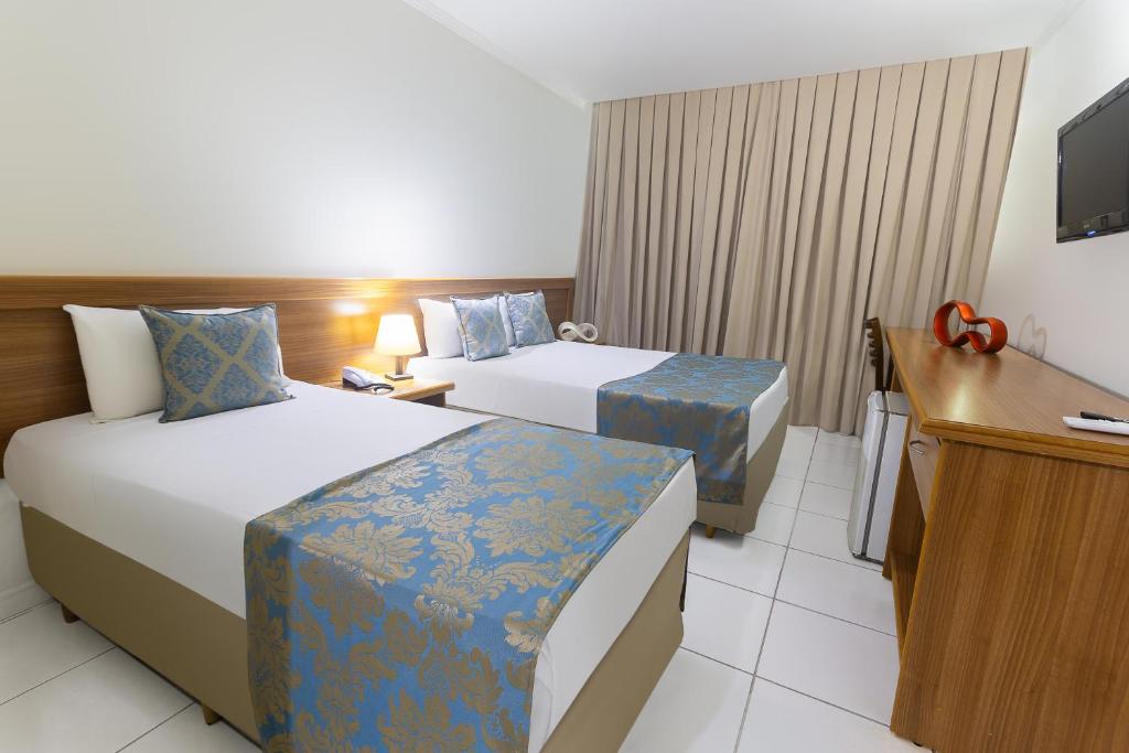 ein Hotelzimmer mit 2 Betten und einem TV in der Unterkunft Hotel Dan Inn Express Ribeirão Preto in Ribeirão Preto