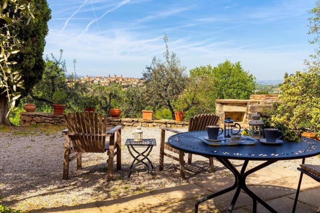 un patio con tavolo e sedie e vista di Wunderschöne Ferienwohnung in Monte San Savino mit gemeinschaftlichem Pool, Garten und Grill a Monte San Savino