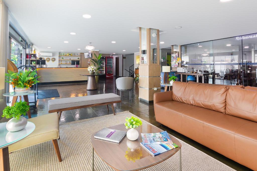 una sala de estar con un sofá y una mesa en Hotel Dan Inn Express Ribeirão Preto By Nacional Inn, en Ribeirão Preto
