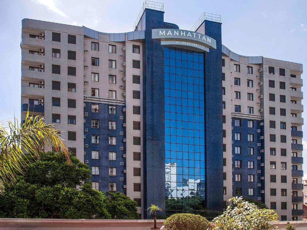 un edificio con un cartel en la parte delantera en Manhattan Porto Alegre by Mercure, en Porto Alegre