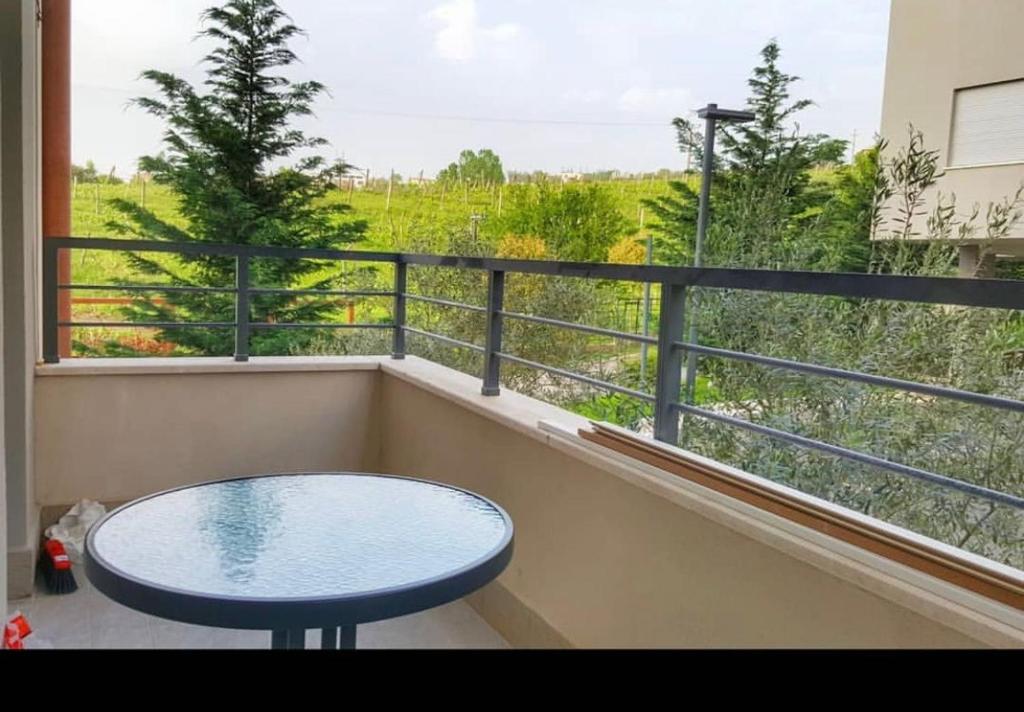 d'un balcon avec une table et une vue sur un champ. dans l'établissement Sunrise Comforts, à Tirana
