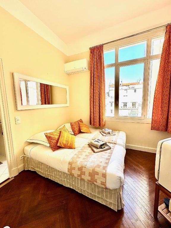 ein Schlafzimmer mit einem Bett und einem großen Fenster in der Unterkunft Studio au calme à deux pas du Palais des Festivals in Cannes