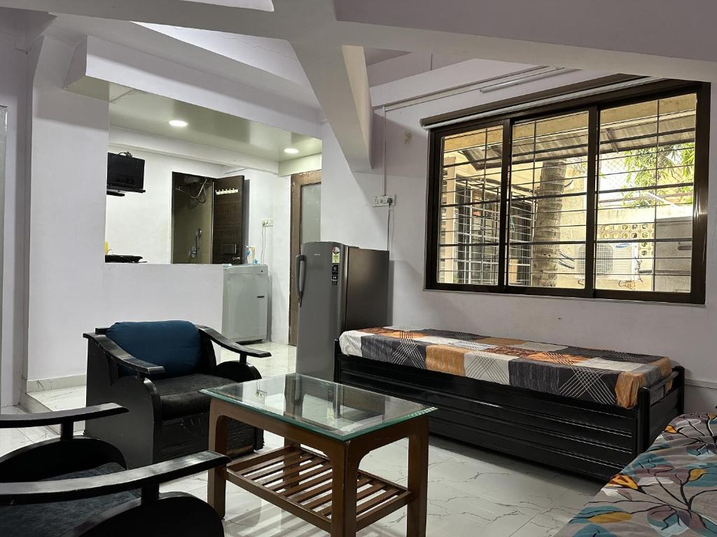 a room with a bed and a chair and a table at Ravish Apartment, Juhu in Mumbai