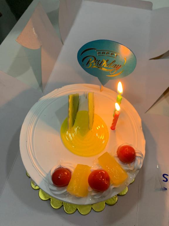 a birthday cake with a candle on a table at The LUTF in New Delhi