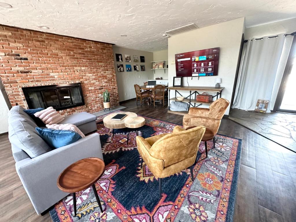 sala de estar con sofá, sillas y chimenea en Hefner Loft, en Oklahoma City