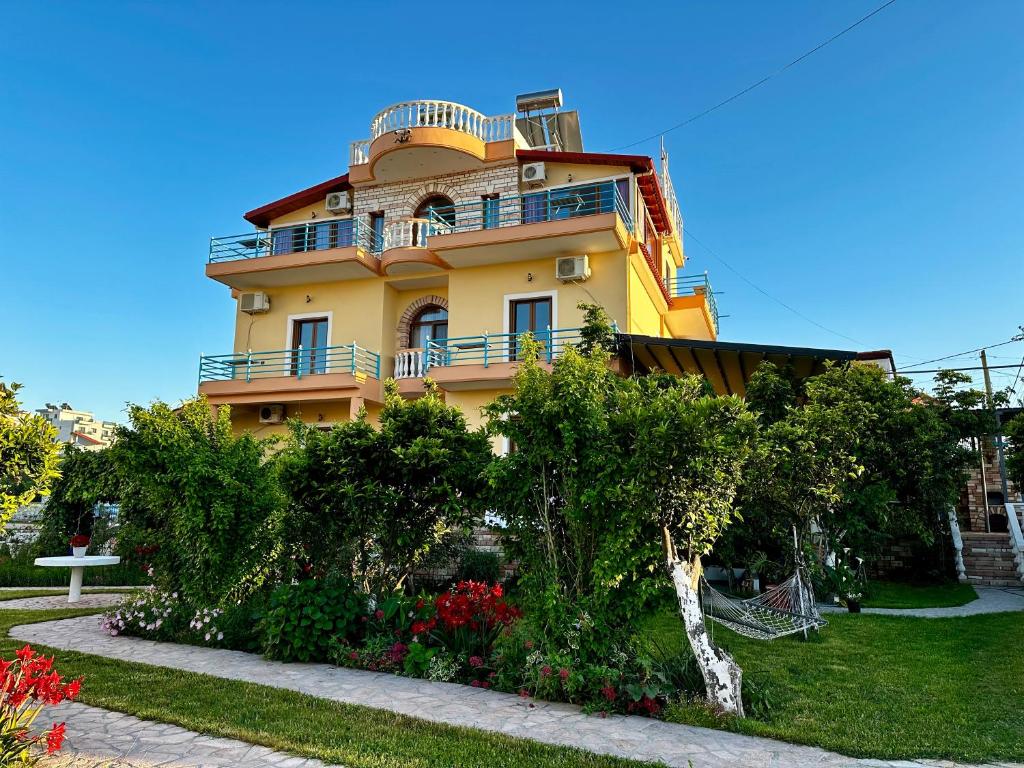un edificio giallo con balconi in cima di Vila Laura a Ksamil