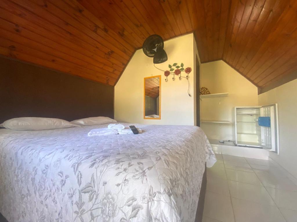 um quarto com uma cama branca e um tecto de madeira em Pousada Portal de Lumiar em Lumiar