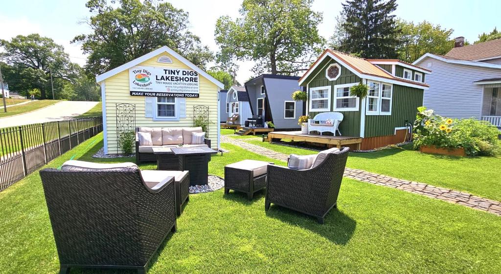 um quintal com cadeiras e uma pequena casa em Tiny Digs Lakeshore - Tiny House Lodging em Muskegon
