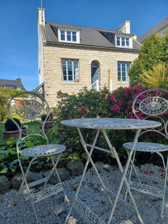 una mesa y dos sillas frente a una casa en Le Banellou, en Quimper