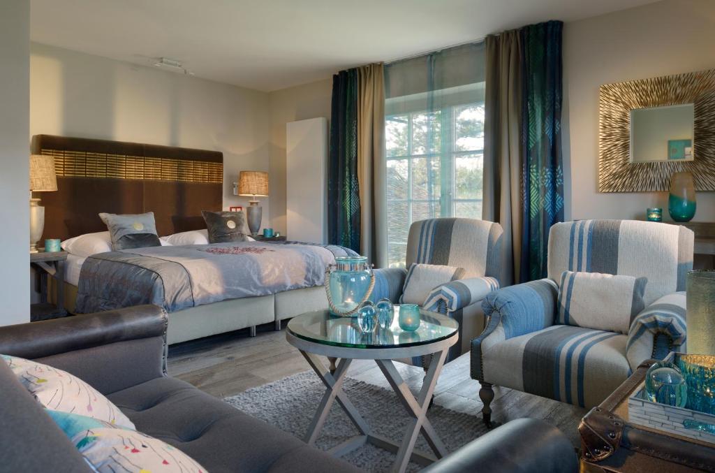 Schlafzimmer mit einem Bett, einem Tisch und Stühlen in der Unterkunft Hotel Duene in Rantum