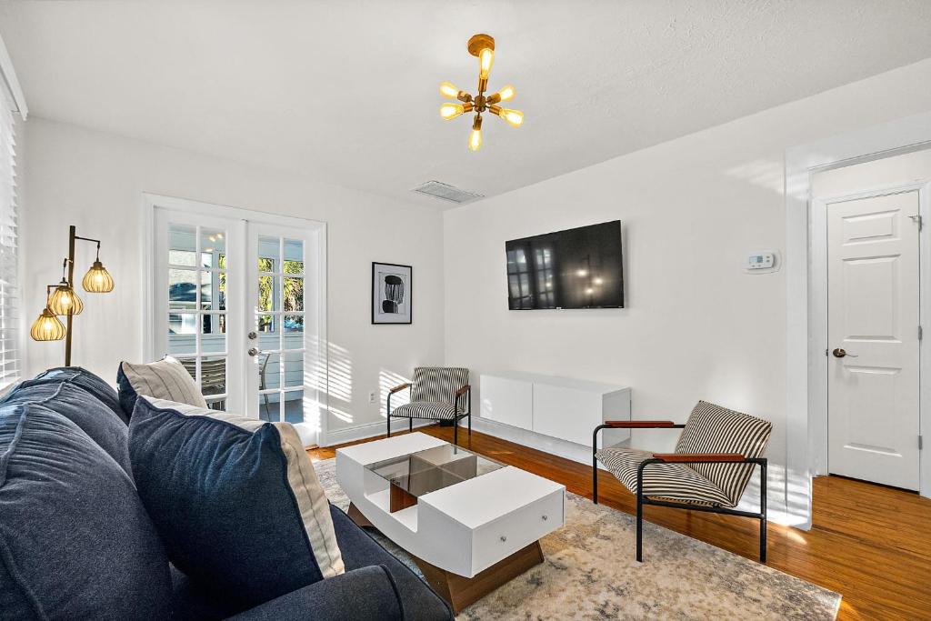 Una sala de estar con un sofá azul y una mesa. en Private Uptown Flat - Walk to Nights of Lights!, en St. Augustine