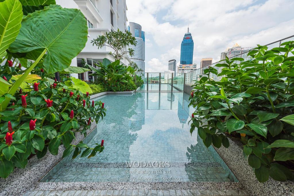 een zwembad in het midden van een gebouw met planten bij Quill Residence by Wodages in Kuala Lumpur