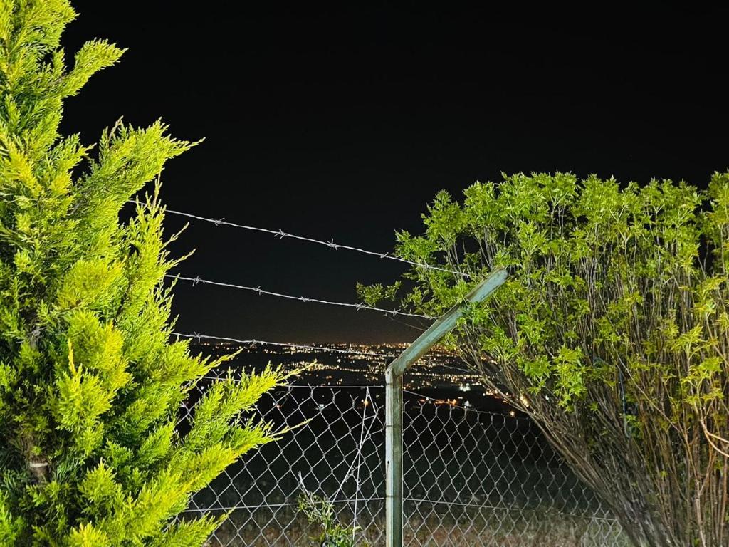 une clôture à maillons avec des arbres en arrière-plan dans l'établissement فيلا الجبل, à Sūf