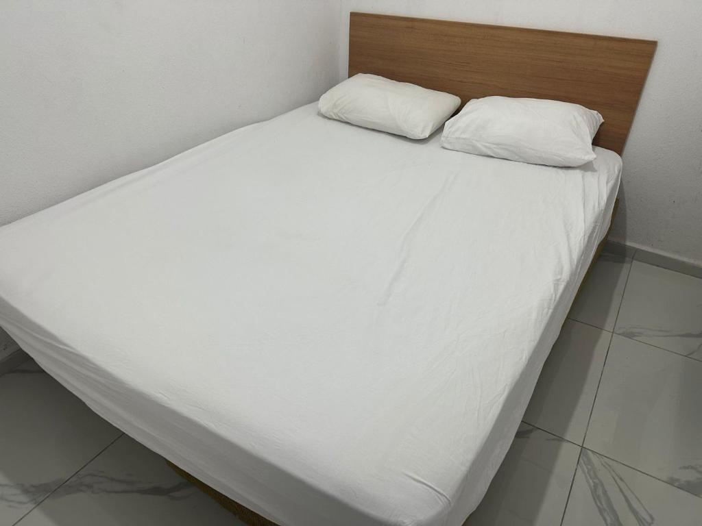 un letto con lenzuola bianche e 2 cuscini di Nr1 Pansiyon a Çanakkale