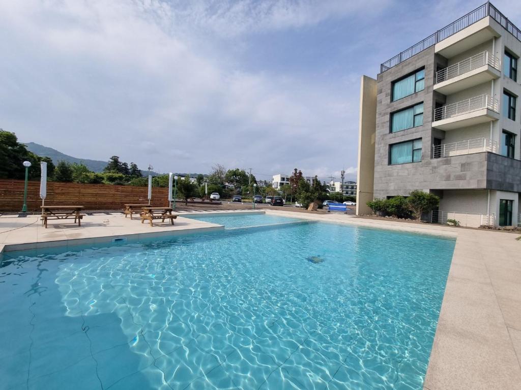 a swimming pool in front of a building at Grand Mer Hotel Seogwipo Ocean in Seogwipo