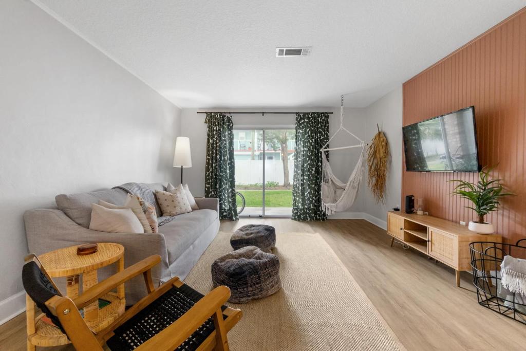 a living room with a couch and a tv at Island Suite - Walk to Downtown! in Saint Augustine