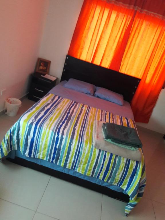 1 dormitorio con 1 cama con un edredón colorido en Casa 4, en Medellín
