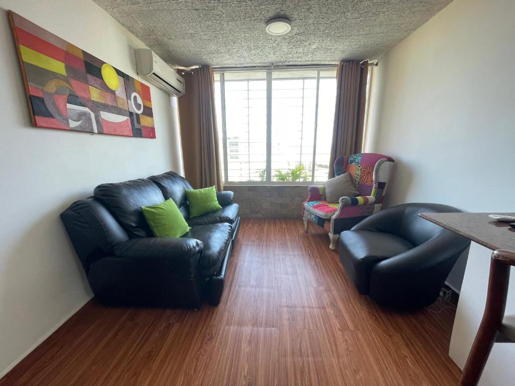 sala de estar con mesa y muebles de cuero negro en Apartamento para viajeros Aeropuerto Maiquetia, en Catia La Mar