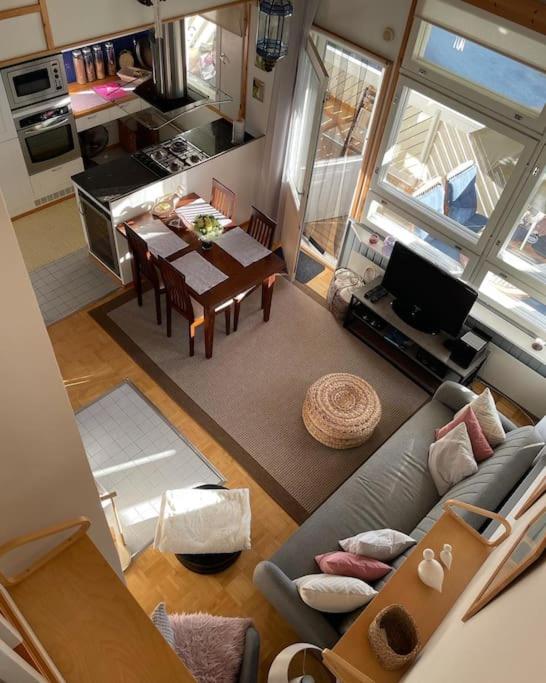 a living room with a couch and a table and a kitchen at Tahkontilhi in Kuopio