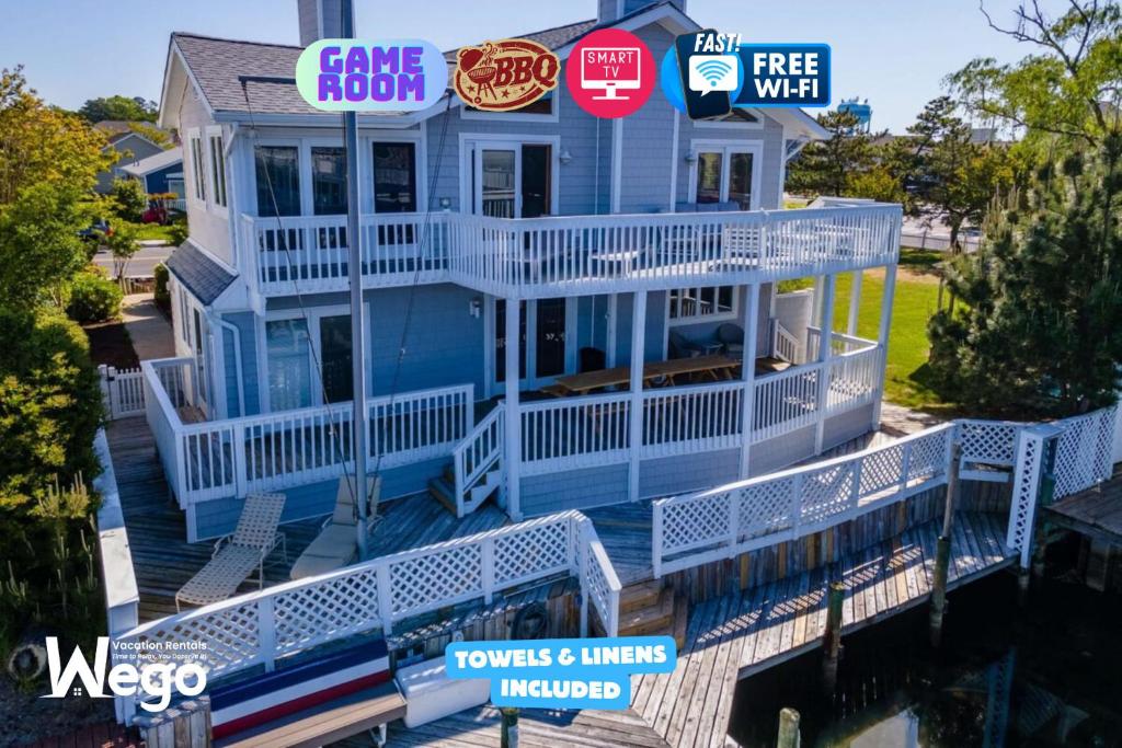 a house with a wrap around porch with a wrap around deck at Luxury Waterfront Villa Dock Game Room Sunset Views in Ocean City