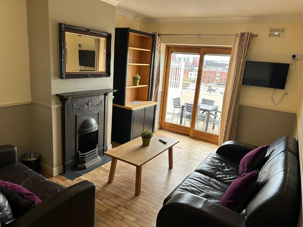 a living room with a couch and a fireplace at Gogartys Temple Bar Apartments in Dublin