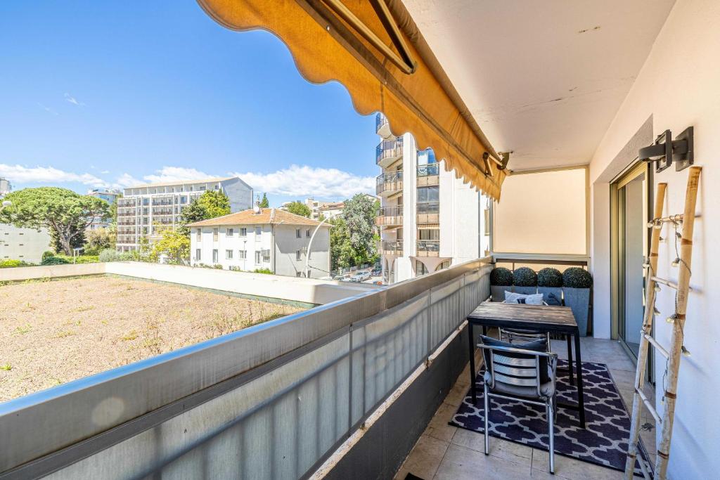 un balcon avec une table et des chaises sur un immeuble dans l'établissement Bright apartment near the Croisette - Cannes, à Cannes