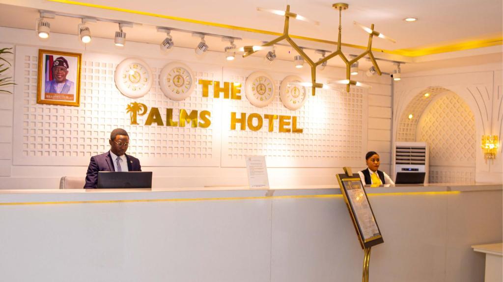 two people sitting at a counter in a restaurant at The Palms Hotel in Abuja