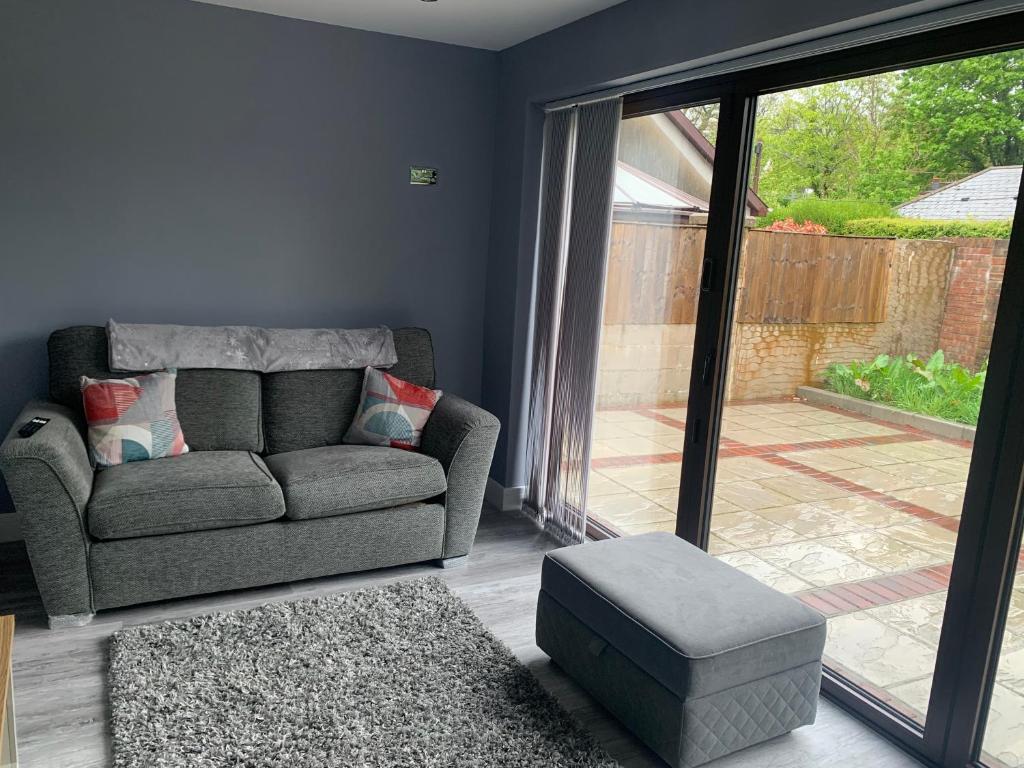 a living room with a couch and a glass door at Ty Haf in Aberdare