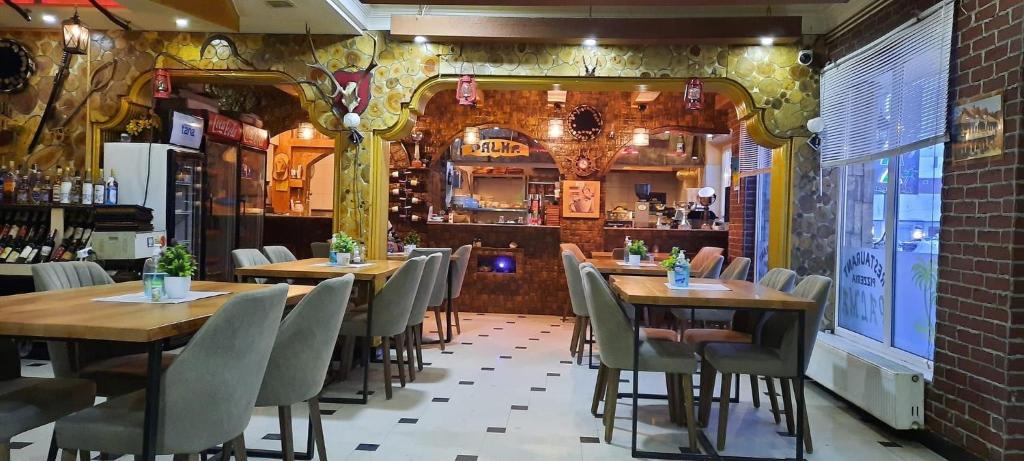 un restaurante con mesas de madera y sillas en una habitación en Hotel Palma, en Dragash