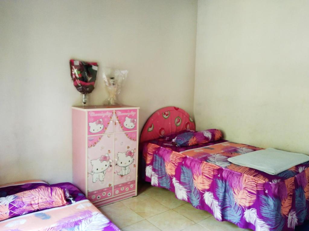 una habitación con 2 camas y un tocador. en Homestay Desa Wisata Silokek, en Duriangadang