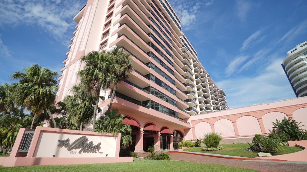 un gran edificio con palmeras delante en Oceanview Apartment on the beach 123 en Miami Beach