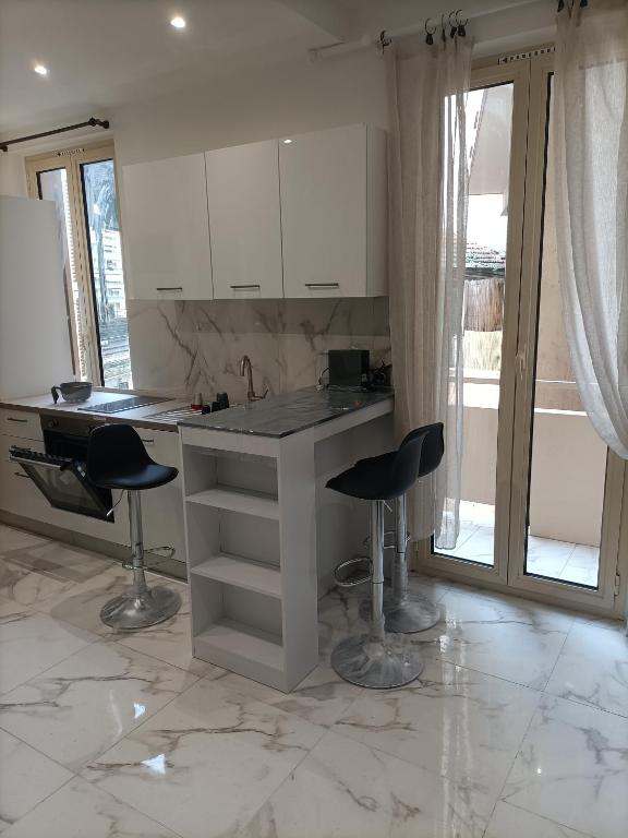 - une cuisine avec un comptoir et deux tabourets dans une pièce dans l'établissement Appartement confortable a proximite de la mer., à Nice