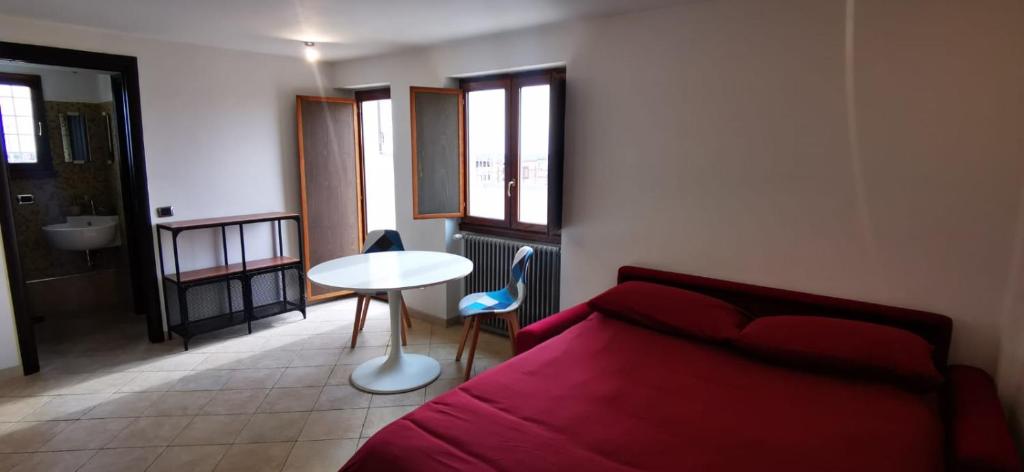 a bedroom with a red bed and a table and window at Penthouse loft with view in Rome