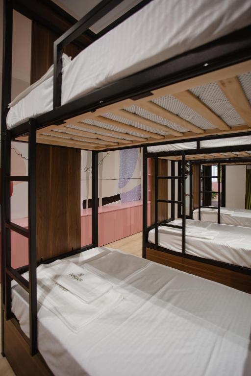 2 literas con sábanas blancas en una habitación en Corner Hostel, en Shkodër