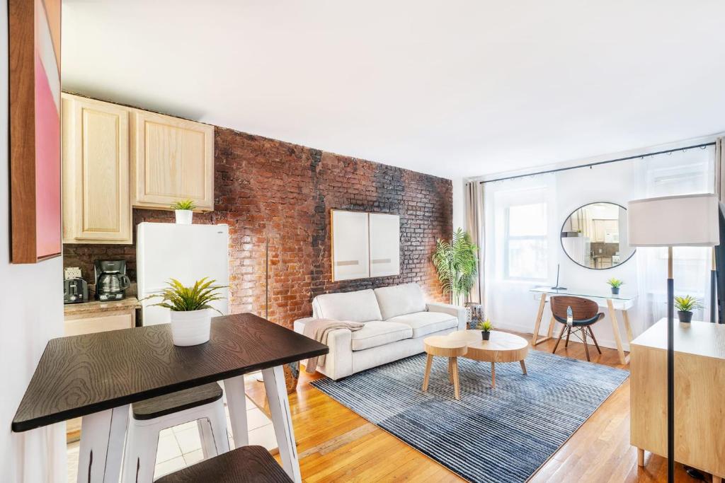 - un salon avec un canapé blanc et un mur en briques dans l'établissement 350-1A Gramercy New 1BR Sleeps4 Newly Furnished, à New York