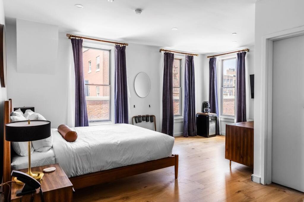 a bedroom with a bed and some windows at Canal View, DTWN Bangor, Steps to great Restaurants, Room # 210 in Bangor