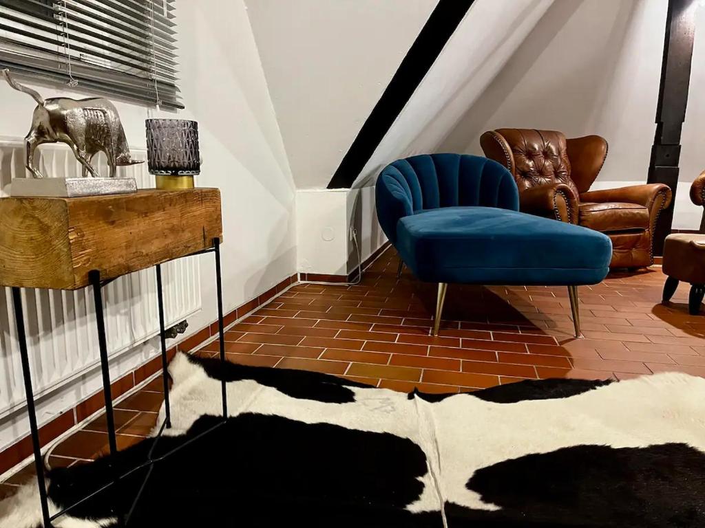 ein Wohnzimmer mit einem blauen Stuhl und einem Tisch in der Unterkunft Luxurious loft on 2 floors in Köln