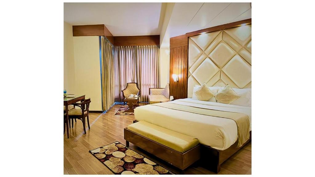 um quarto de hotel com uma cama grande e uma secretária em River Grand View Resort and SPA Manali - A River side Property em Manali