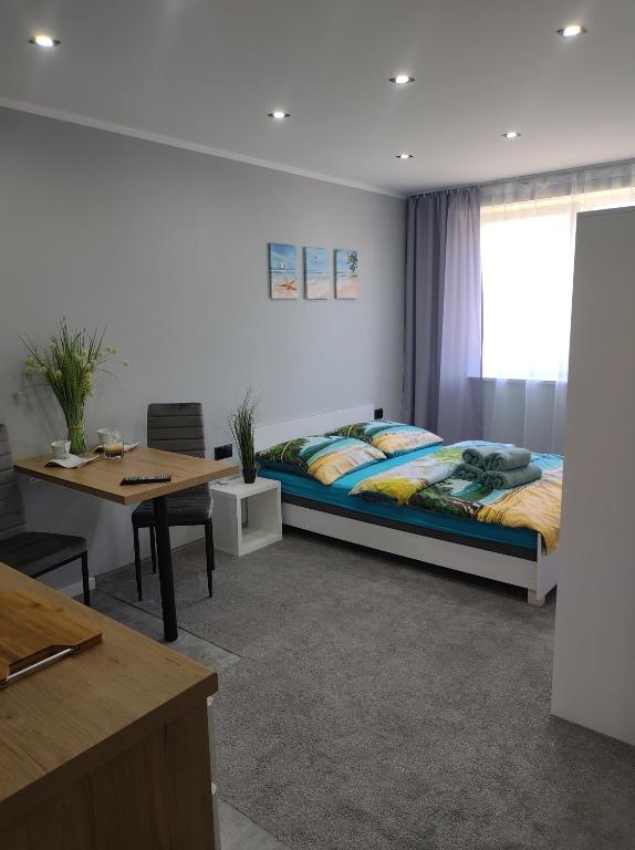 1 dormitorio con cama, mesa y escritorio en Pokoje gościnne U Bosmana en Dźwirzyno