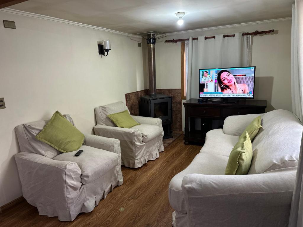 un soggiorno con 2 divani e una TV a schermo piatto di Casa Ann a Osorno