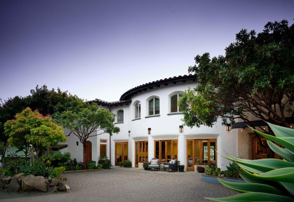 a large white house with a courtyard at El Colibri Hotel & Spa in Cambria